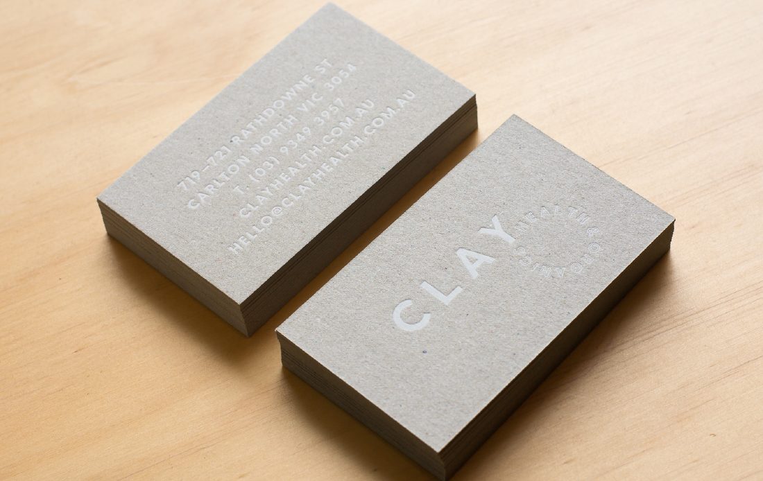Two stacks of business cards on plywood surface